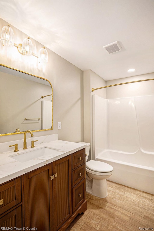 6400 N Seymour Rd, Flushing, MI 48433 - bathroom featuring wood finished floors, vanity, toilet, and shower / washtub combination