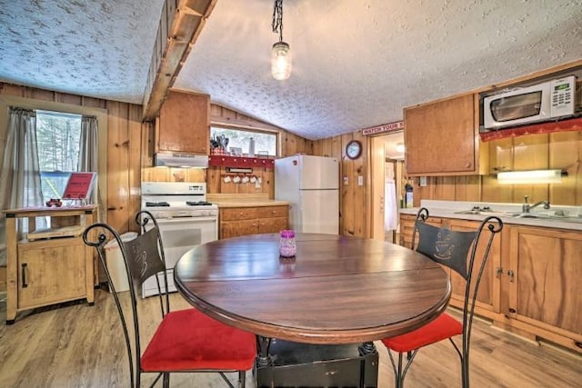 4290 Clark St, Lewiston, MI 49756 - dining space with a textured ceiling, vaulted ceiling, healthy amount of natural light, light wood finished floors, and wooden walls