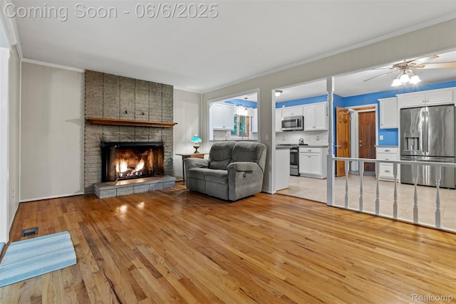 36963 Heatherton Dr, Farmington, MI 48335 - living area featuring light wood-style floors, crown molding, a fireplace, and ceiling fan