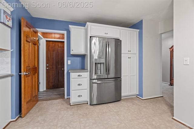 36963 Heatherton Dr, Farmington, MI 48335 - kitchen with stainless steel fridge, white cabinetry, and baseboards