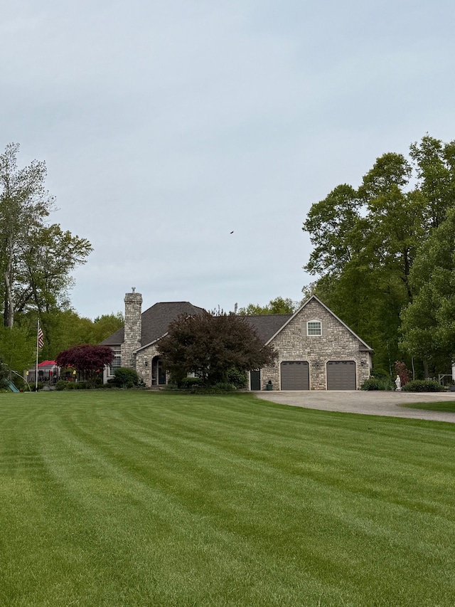 6523 Jones Rd, North Branch, MI 48461 - view of front of house with stone siding, a front lawn, driveway, and a chimney
