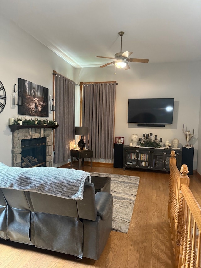 6523 Jones Rd, North Branch, MI 48461 - living area with ceiling fan, wood finished floors, and a stone fireplace
