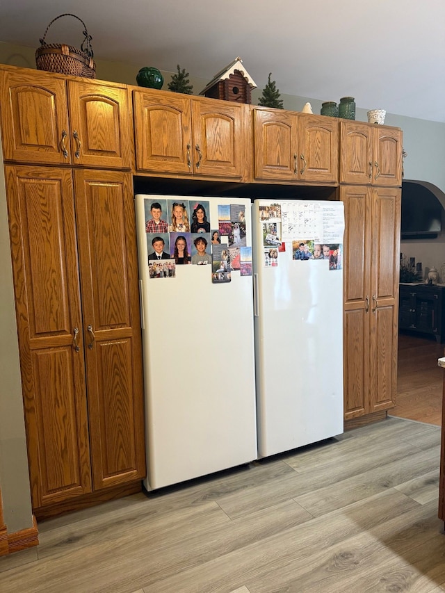 6523 Jones Rd, North Branch, MI 48461 - kitchen with light wood-type flooring, freestanding refrigerator, and brown cabinetry