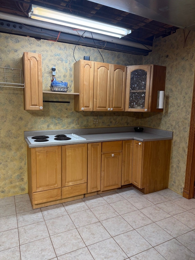 6523 Jones Rd, North Branch, MI 48461 - kitchen with wallpapered walls, glass insert cabinets, light tile patterned floors, white electric stovetop, and brown cabinets