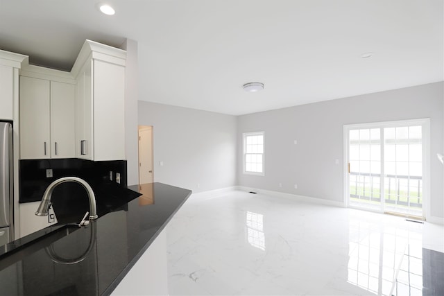 4116 Split Rail Dr, Fenton, MI 48430 - kitchen with open floor plan, marble tiled floors, baseboards, dark countertops, and white cabinetry