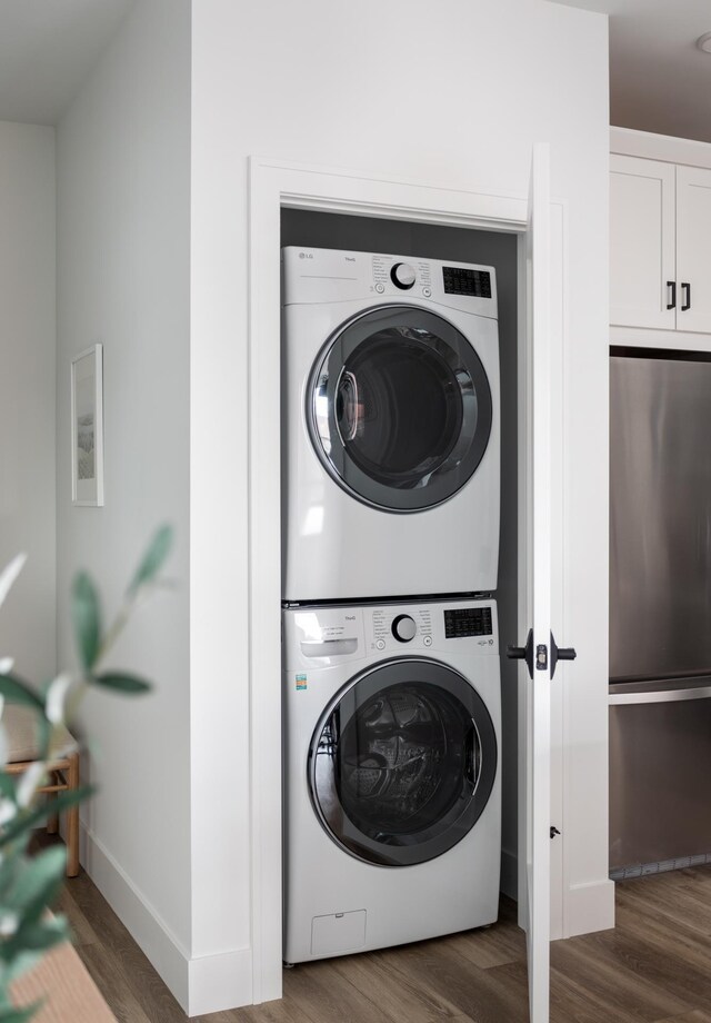 222 E State St, Traverse City, MI 49684 - laundry area with stacked washer and clothes dryer, wood finished floors, and baseboards