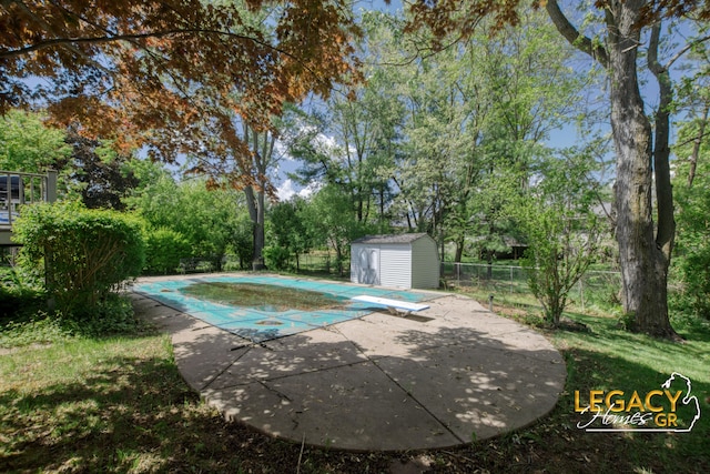 3051 Lantana Ct SE, Kentwood, MI 49512 - view of swimming pool with a diving board, a patio, a fenced backyard, and view of wooded area