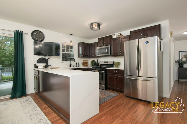 3051 Lantana Ct SE, Kentwood, MI 49512 - kitchen with stainless steel appliances, a peninsula, dark brown cabinetry, and light countertops