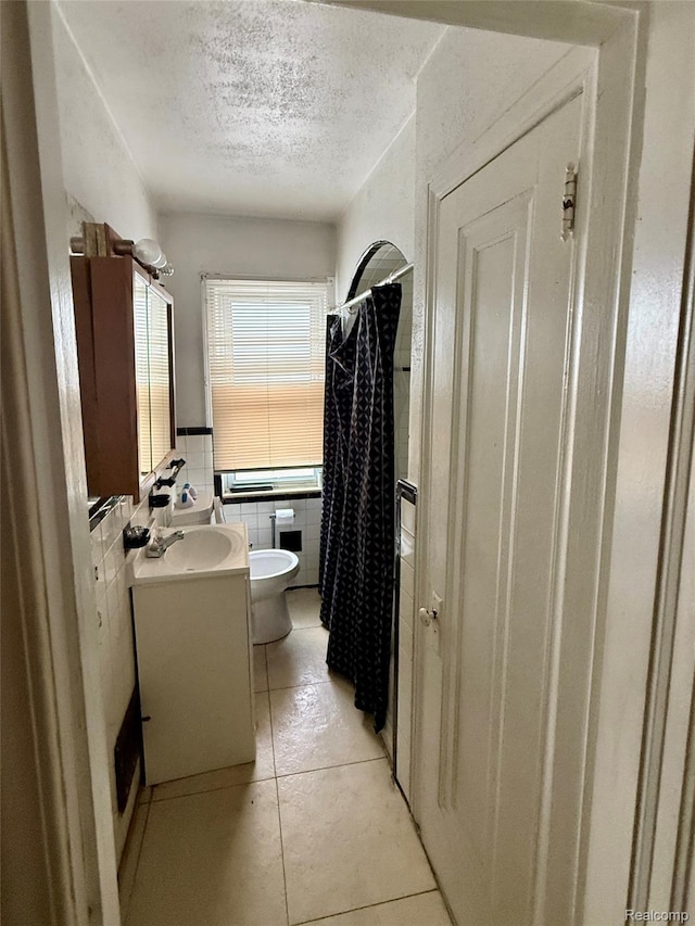 15898 Asbury Park, Detroit, MI 48227 - bathroom with a textured ceiling, vanity, toilet, tile patterned flooring, and tile walls
