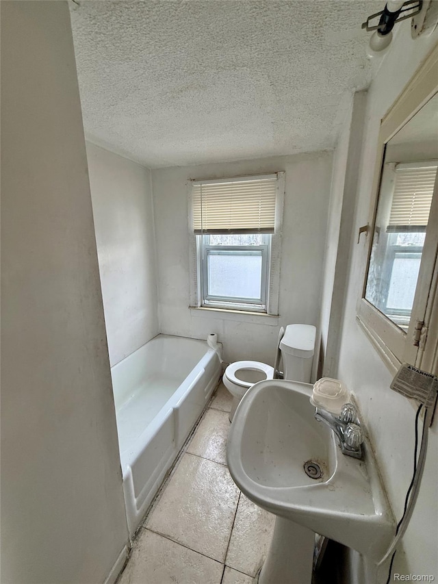 15898 Asbury Park, Detroit, MI 48227 - bathroom featuring a bath, toilet, a textured ceiling, and a sink