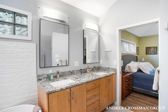 16993 Firefly Rdg, West Olive, MI 49460 - bathroom featuring connected bathroom, double vanity, wood finished floors, a bath, and vaulted ceiling