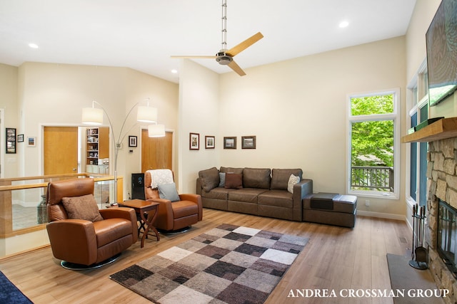 16993 Firefly Rdg, West Olive, MI 49460 - living area with wood finished floors, a stone fireplace, a towering ceiling, a ceiling fan, and recessed lighting