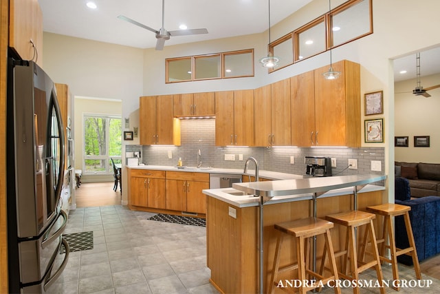 16993 Firefly Rdg, West Olive, MI 49460 - kitchen with appliances with stainless steel finishes, ceiling fan, a peninsula, a sink, and a towering ceiling