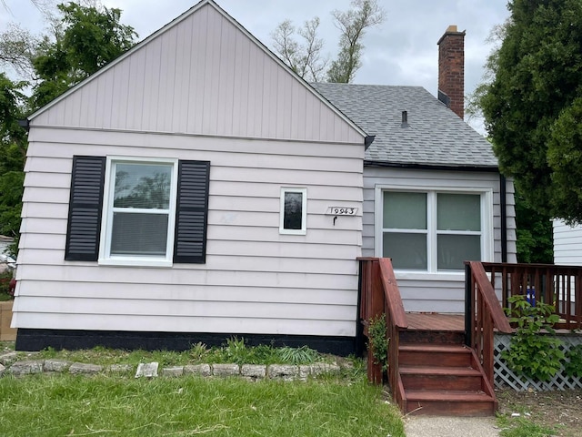 19943 Southfield Fwy, Detroit, MI 48235 - back of house with a shingled roof, a deck, and a chimney