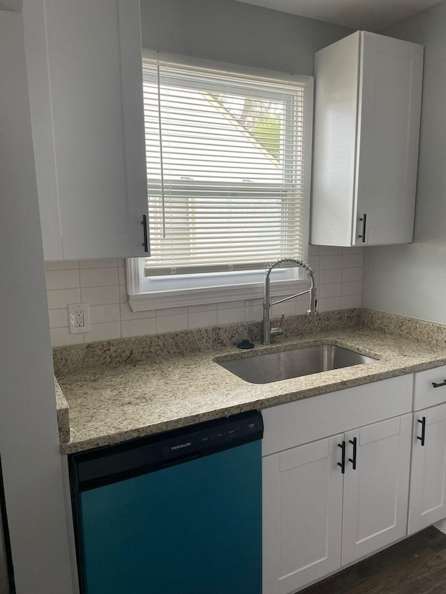19943 Southfield Fwy, Detroit, MI 48235 - kitchen featuring dishwashing machine, a sink, tasteful backsplash, and white cabinets