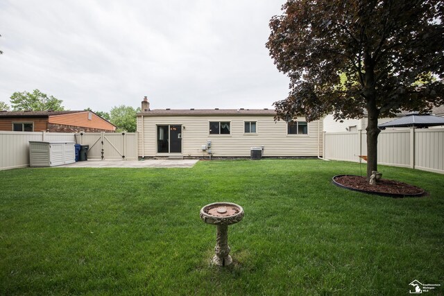 43800 Proctor Rd, Canton, MI 48188 - rear view of house with a patio area, a gate, a chimney, and central AC unit