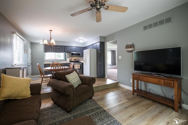 43800 Proctor Rd, Canton, MI 48188 - living room with light wood finished floors, a chandelier, a ceiling fan, and baseboards