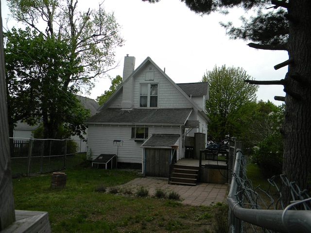 306 N Rowe St, Ludington, MI 49431 - back of property featuring a deck, a chimney, and a shingled roof