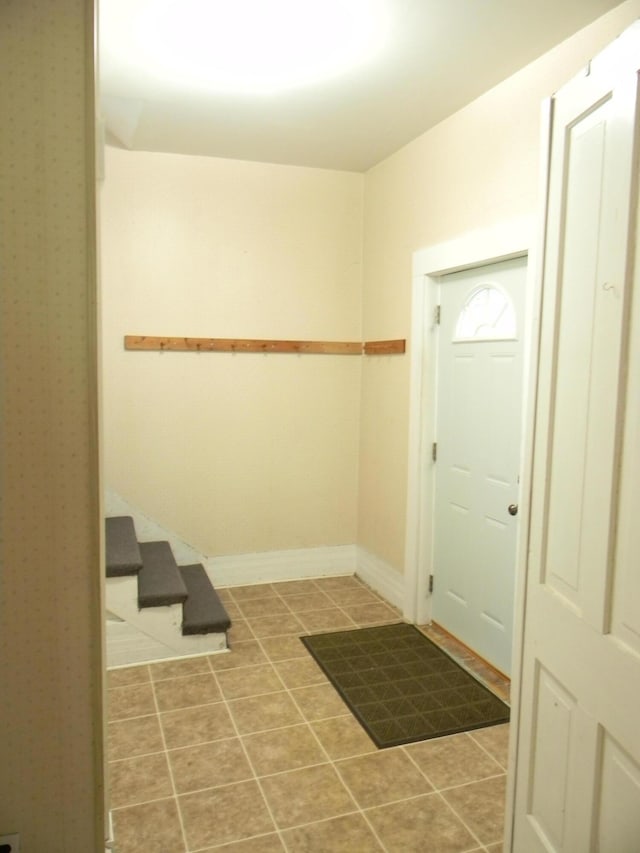 306 N Rowe St, Ludington, MI 49431 - foyer entrance with stairs, baseboards, and tile patterned floors