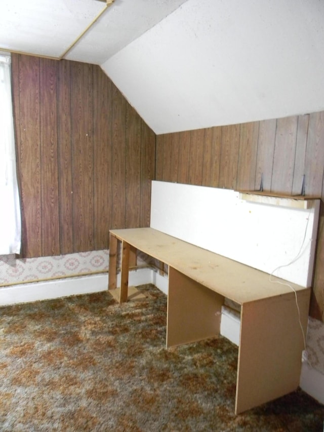306 N Rowe St, Ludington, MI 49431 - unfurnished office with wood walls, vaulted ceiling, and dark colored carpet