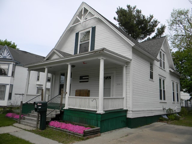306 N Rowe St, Ludington, MI 49431 - view of front of home featuring covered porch and a shingled roof