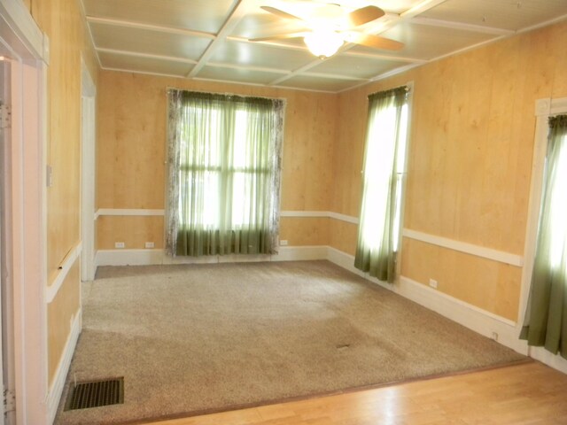 306 N Rowe St, Ludington, MI 49431 - unfurnished room featuring ceiling fan, coffered ceiling, wood finished floors, carpet flooring, and baseboards