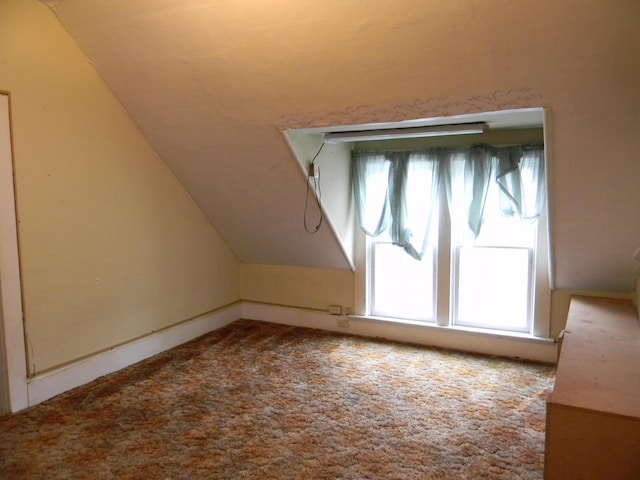 306 N Rowe St, Ludington, MI 49431 - additional living space featuring vaulted ceiling, healthy amount of natural light, and carpet flooring