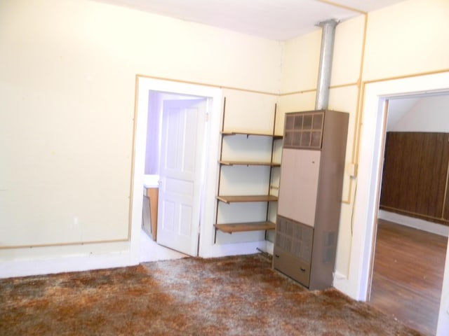 306 N Rowe St, Ludington, MI 49431 - unfurnished bedroom featuring a heating unit and carpet floors