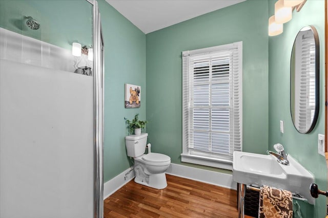 152 National Ave SW, Grand Rapids, MI 49504 - full bathroom featuring toilet, wood finished floors, baseboards, and a shower
