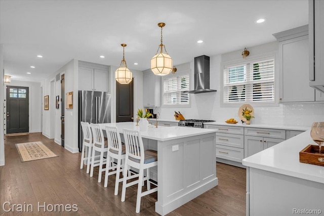 1748 Stanley Blvd, Birmingham, MI 48009 - kitchen with wall chimney exhaust hood, freestanding refrigerator, a center island, a kitchen breakfast bar, and dark wood-style floors