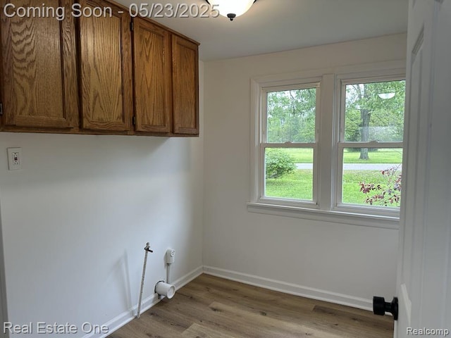 5399 Brobeck St, Flint, MI 48532 - washroom featuring cabinet space, baseboards, and wood finished floors