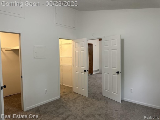 5399 Brobeck St, Flint, MI 48532 - unfurnished bedroom featuring a spacious closet, carpet flooring, a closet, electric panel, and baseboards