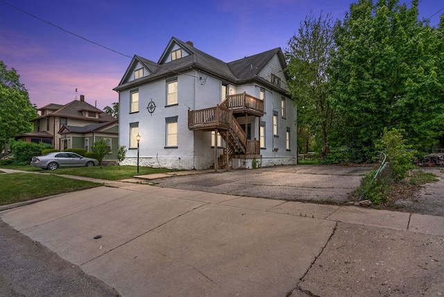612 E 3rd St, Flint, MI 48503 - view of front facade with a balcony, a chimney, and brick siding