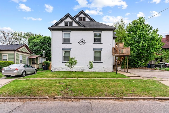 612 E 3rd St, Flint, MI 48503 - view of front facade with stairway, a front yard, a deck, and brick siding