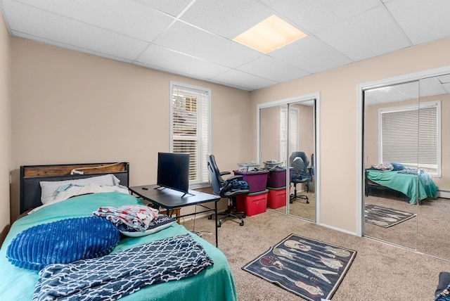 612 E 3rd St, Flint, MI 48503 - carpeted bedroom featuring multiple closets, a paneled ceiling, and a desk
