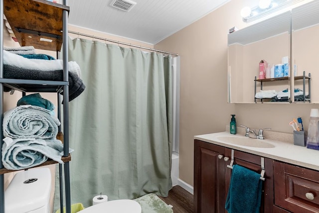 612 E 3rd St, Flint, MI 48503 - bathroom featuring toilet, wood finished floors, shower / tub combo with curtain, and vanity