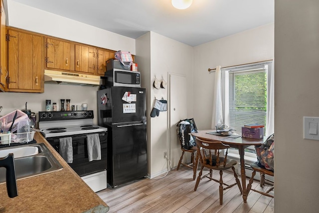 612 E 3rd St, Flint, MI 48503 - kitchen featuring electric range oven, under cabinet range hood, freestanding refrigerator, stainless steel microwave, and light wood-style floors