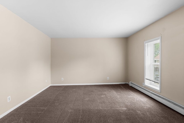 612 E 3rd St, Flint, MI 48503 - spare room featuring a baseboard heating unit, dark carpet, and baseboards