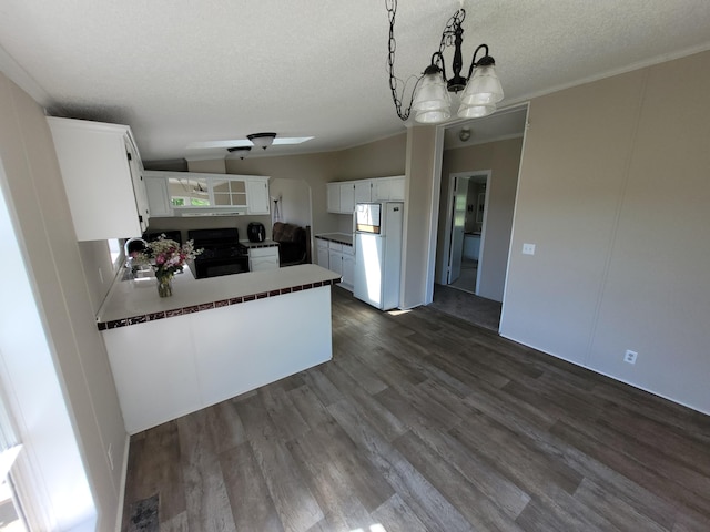 4908 Brookfield Rd, Charlotte, MI 48813 - kitchen featuring freestanding refrigerator, black gas stove, dark wood-style floors, a peninsula, and a textured ceiling