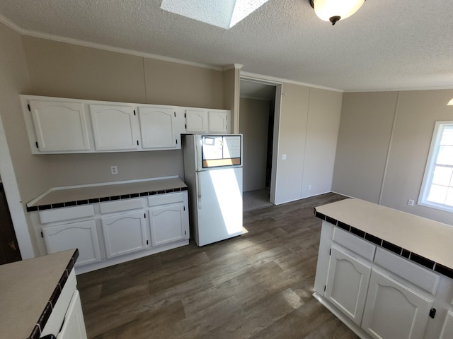 4908 Brookfield Rd, Charlotte, MI 48813 - kitchen with freestanding refrigerator, white cabinetry, ornamental molding, a textured ceiling, and dark wood-style floors