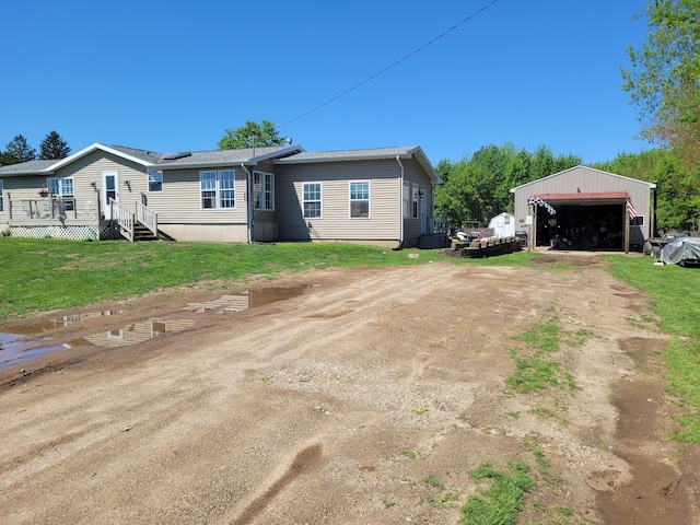 4908 Brookfield Rd, Charlotte, MI 48813 - back of house with driveway, a garage, and an outbuilding