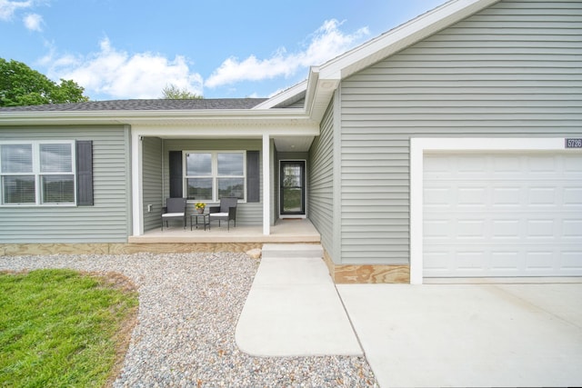 5726 Joshua Dr, Eaton Rapids, MI 48827 - property entrance with a porch, a garage, and a shingled roof