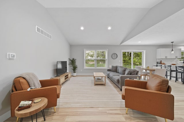 5726 Joshua Dr, Eaton Rapids, MI 48827 - living room with lofted ceiling, recessed lighting, light wood-type flooring, and baseboards