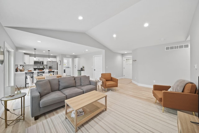 5726 Joshua Dr, Eaton Rapids, MI 48827 - living area featuring vaulted ceiling, recessed lighting, and baseboards