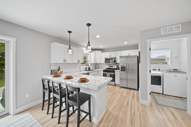 5726 Joshua Dr, Eaton Rapids, MI 48827 - kitchen with appliances with stainless steel finishes, independent washer and dryer, a sink, plenty of natural light, and recessed lighting