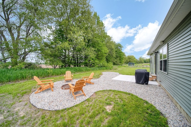5726 Joshua Dr, Eaton Rapids, MI 48827 - view of green lawn featuring a fire pit and a patio area