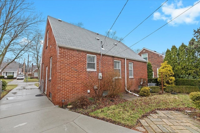8156 Grayfield St, Dearborn Heights, MI 48127 - view of home's exterior with a shingled roof, brick siding, and concrete driveway