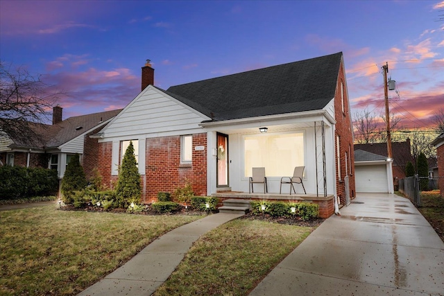 8156 Grayfield St, Dearborn Heights, MI 48127 - view of front facade with brick siding, a yard, a porch, a garage, and an outbuilding