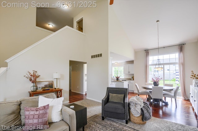4422 Jordan Dr, Grand Blanc, MI 48439 - living area featuring a high ceiling, stairs, dark wood-style floors, and baseboards