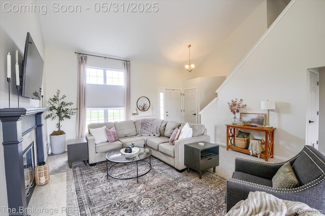 4422 Jordan Dr, Grand Blanc, MI 48439 - living room featuring a fireplace with flush hearth, high vaulted ceiling, a chandelier, and carpet floors